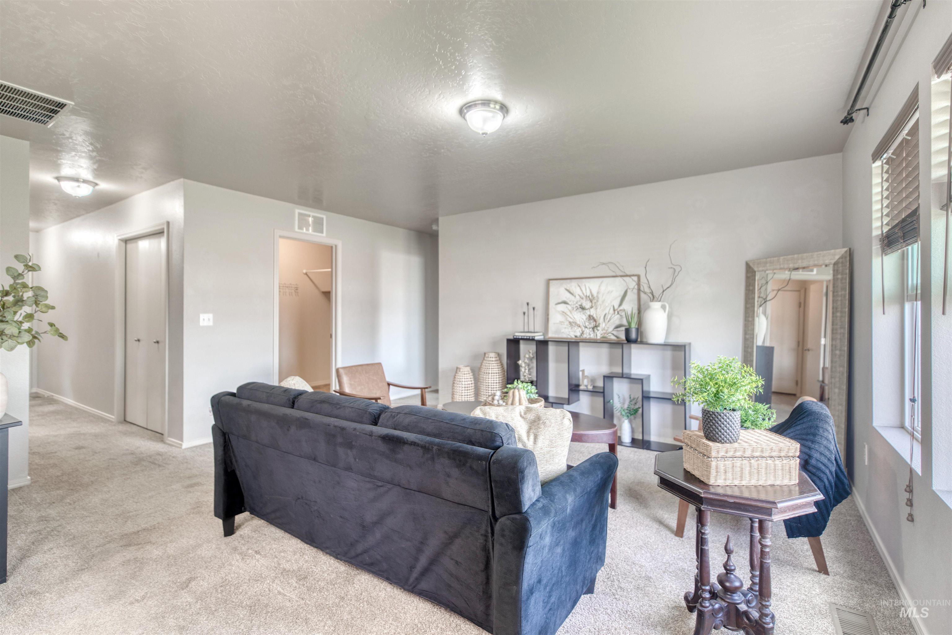 Living room featuring light colored carpet and a textured ceiling