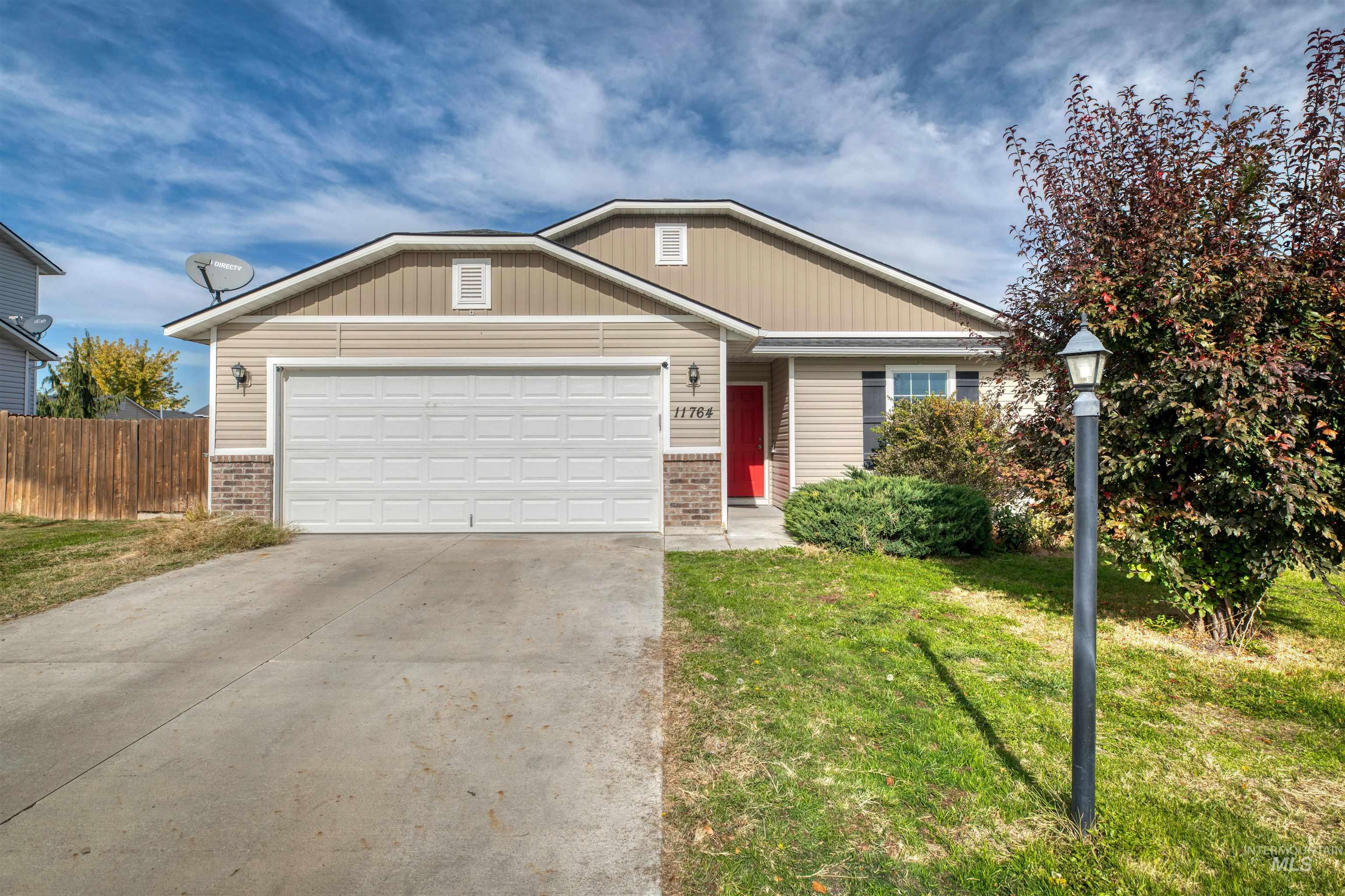 View of front facade with brick siding, concrete driveway, and an attached garage