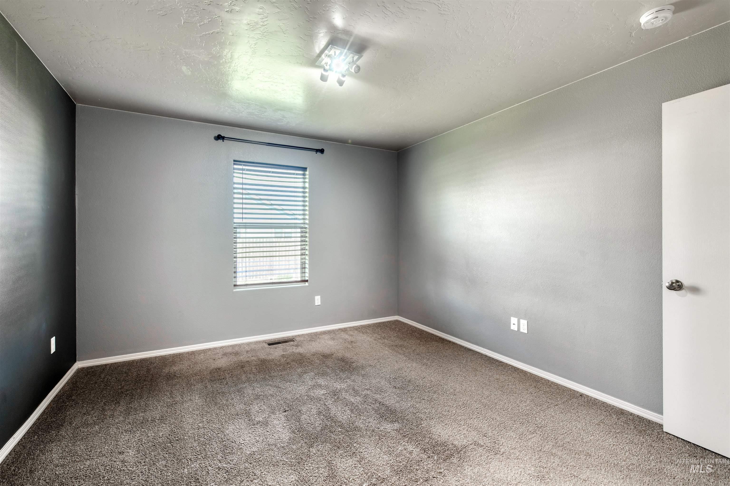 Empty room featuring carpet floors and a textured ceiling