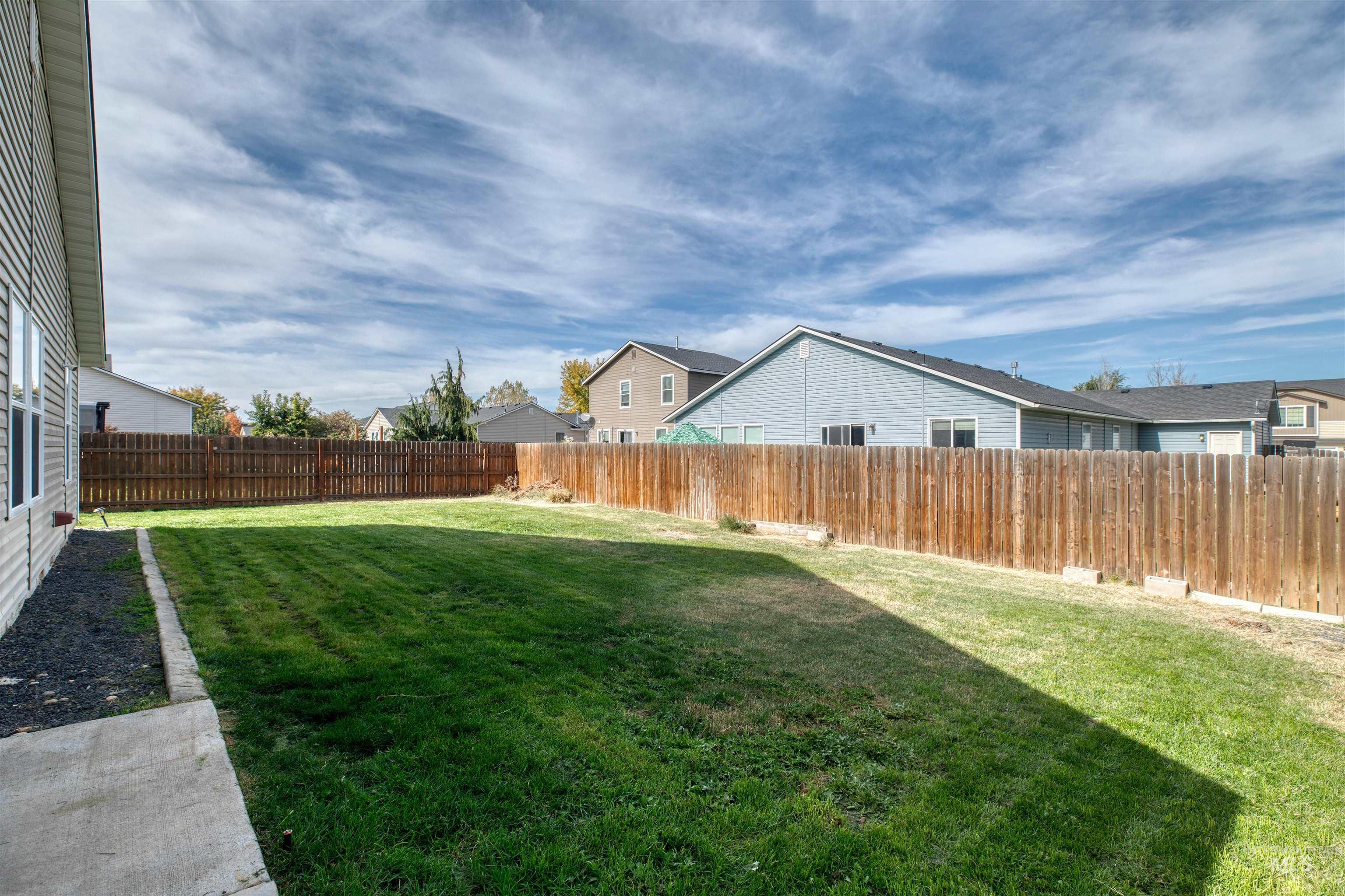 Fenced backyard featuring a residential view