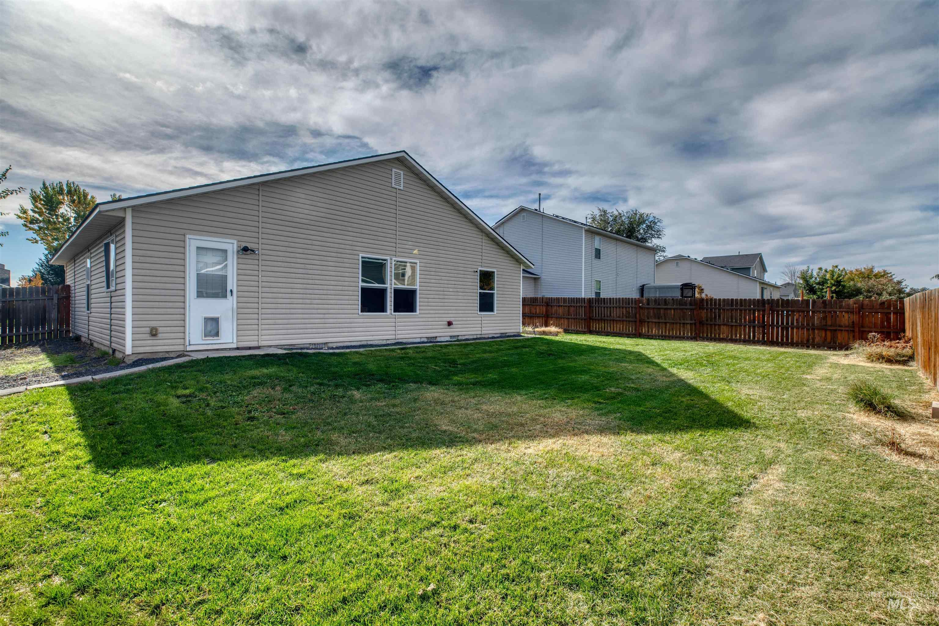 Rear view of house with a fenced backyard