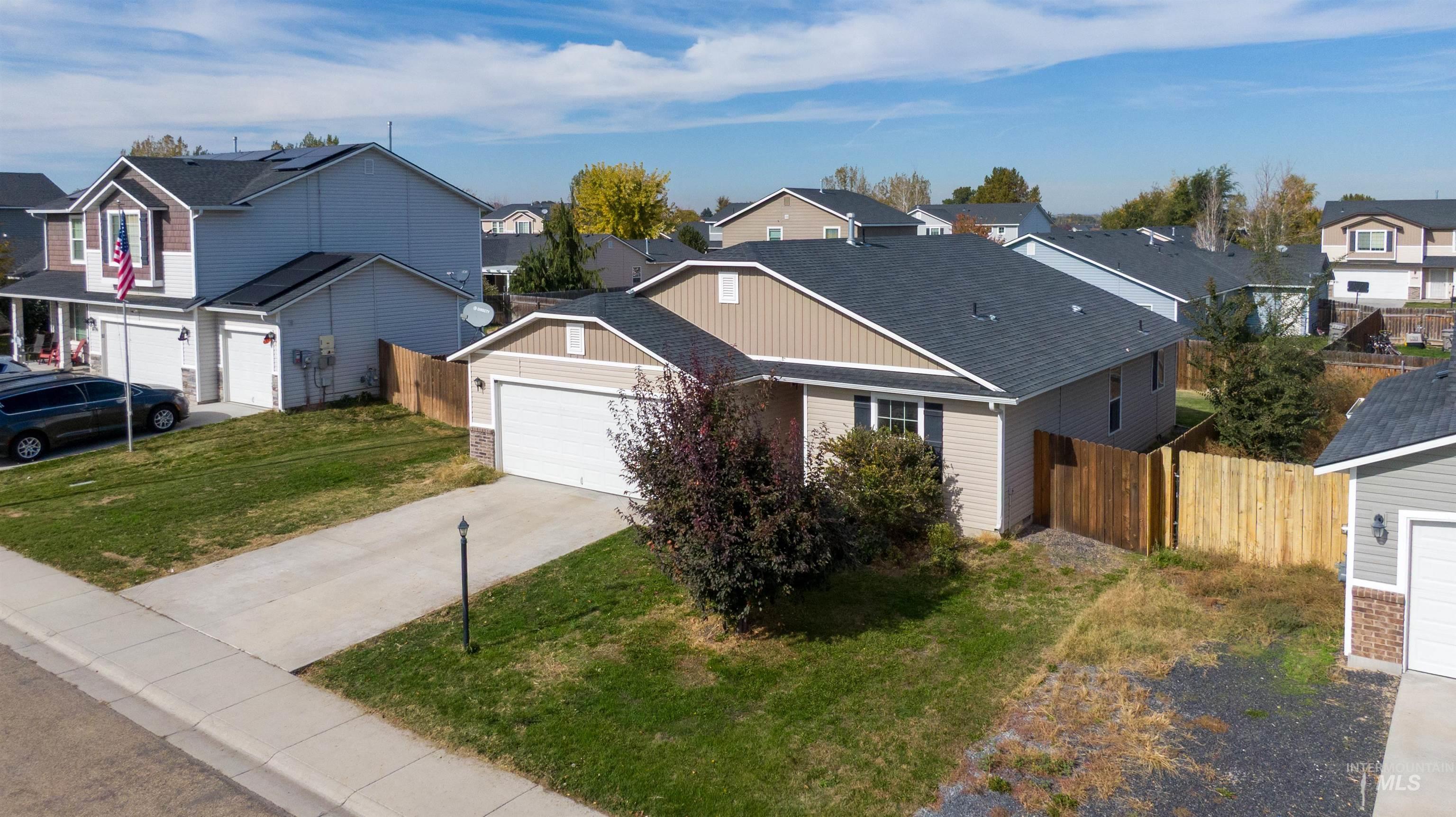 Traditional home featuring a residential view, driveway, a shingled roof, and an attached garage