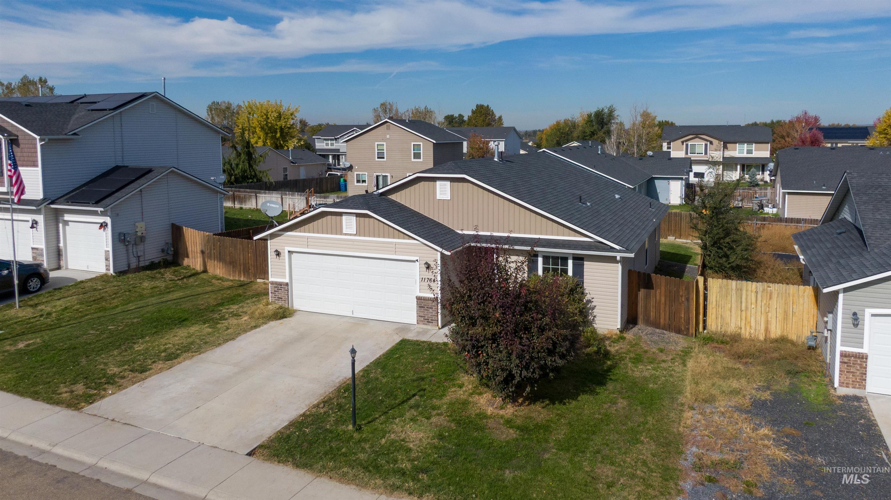View of front of house featuring a residential view, driveway, and a garage
