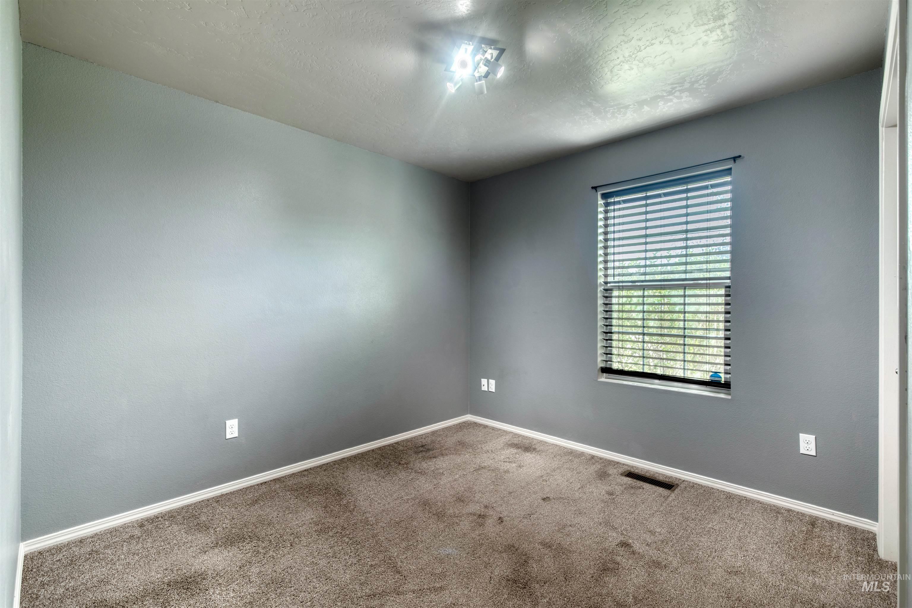 Spare room featuring carpet floors and a textured ceiling
