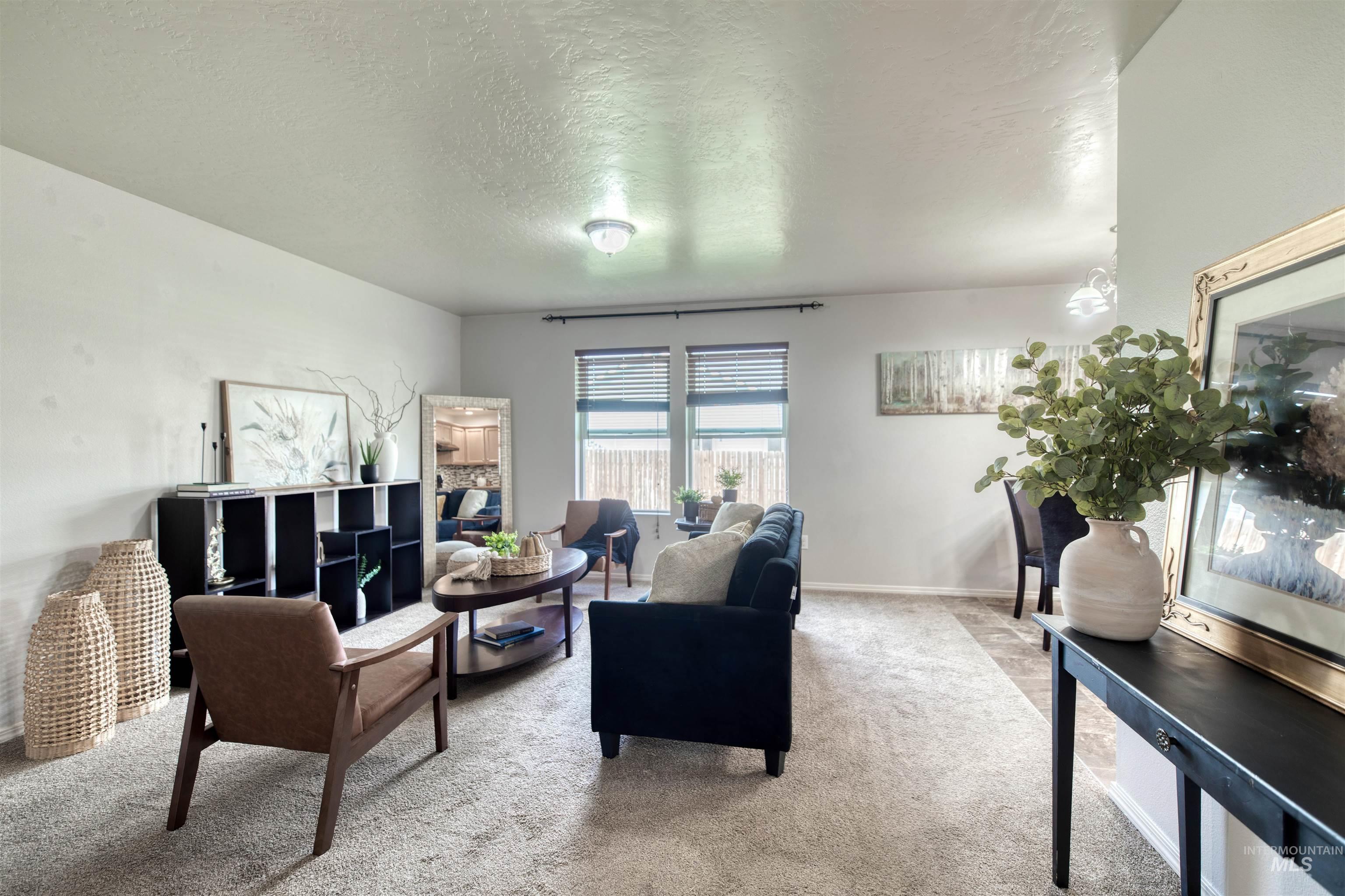 Carpeted living room with a textured ceiling and baseboards