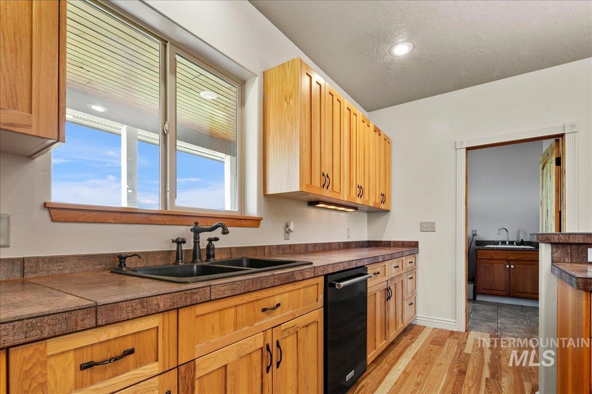 Kitchen with dishwasher and light wood-style floors