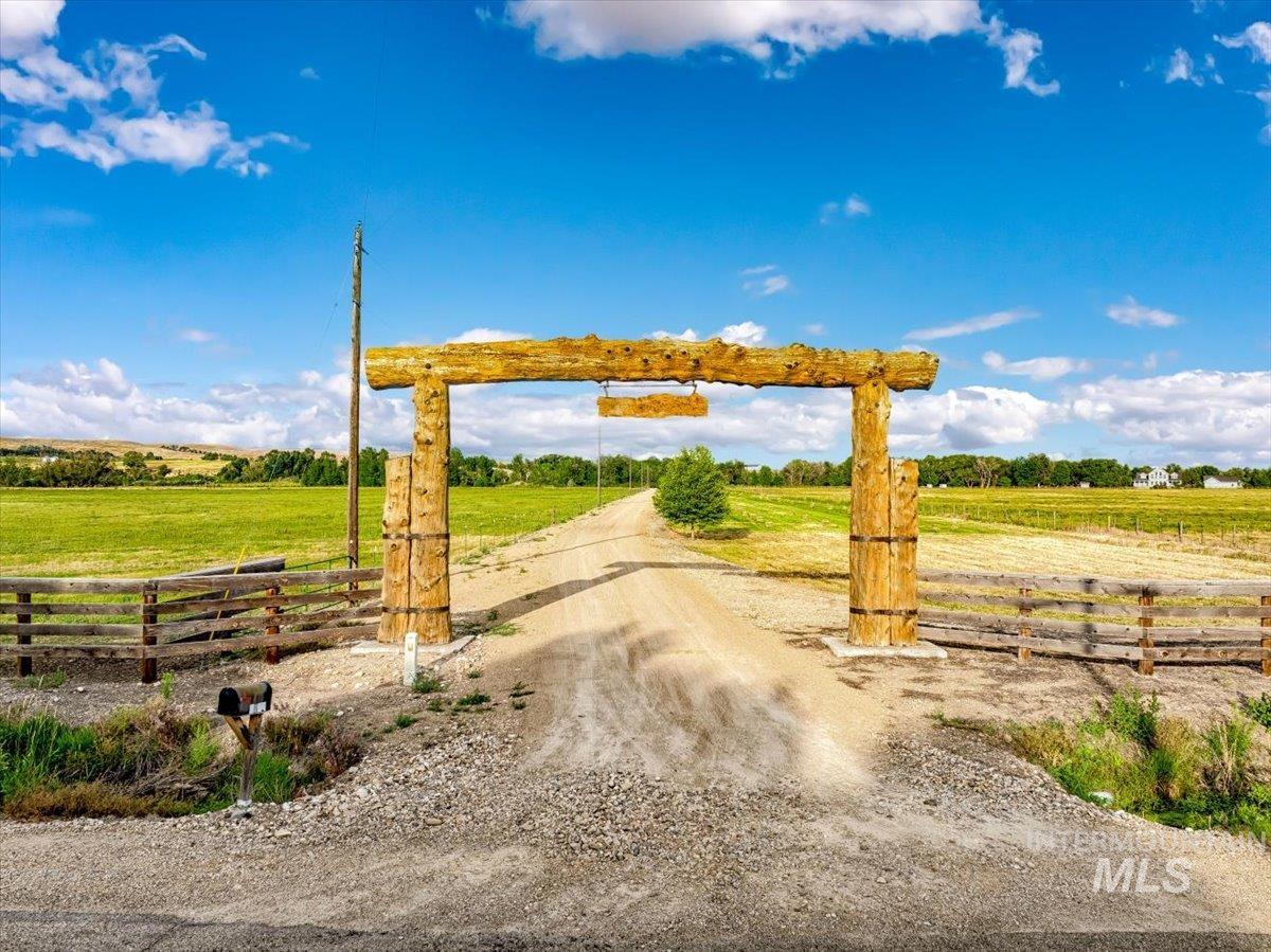View of dirt / gravel road with a view of rural / pastoral area