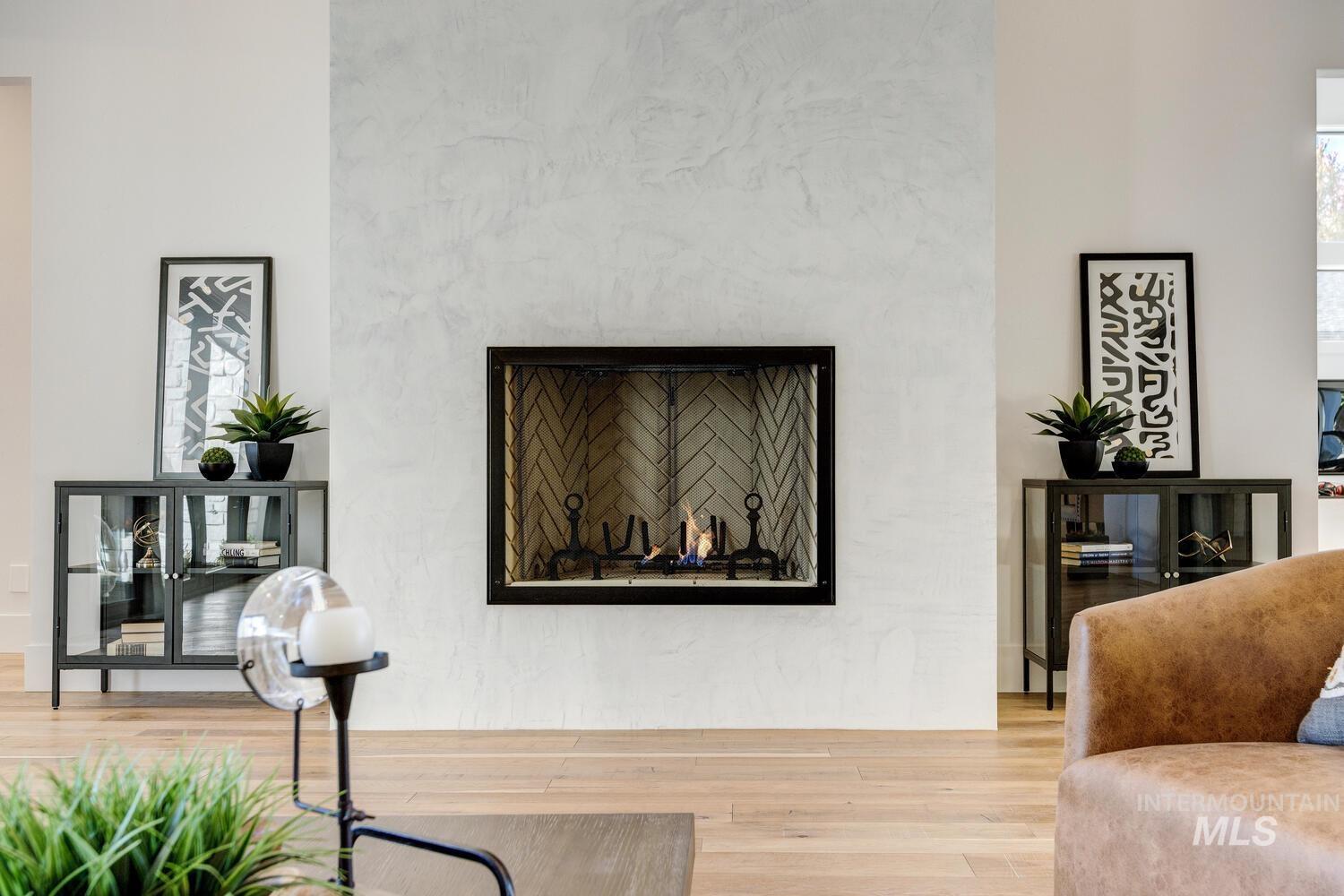 Living room with wood finished floors and a high end fireplace
