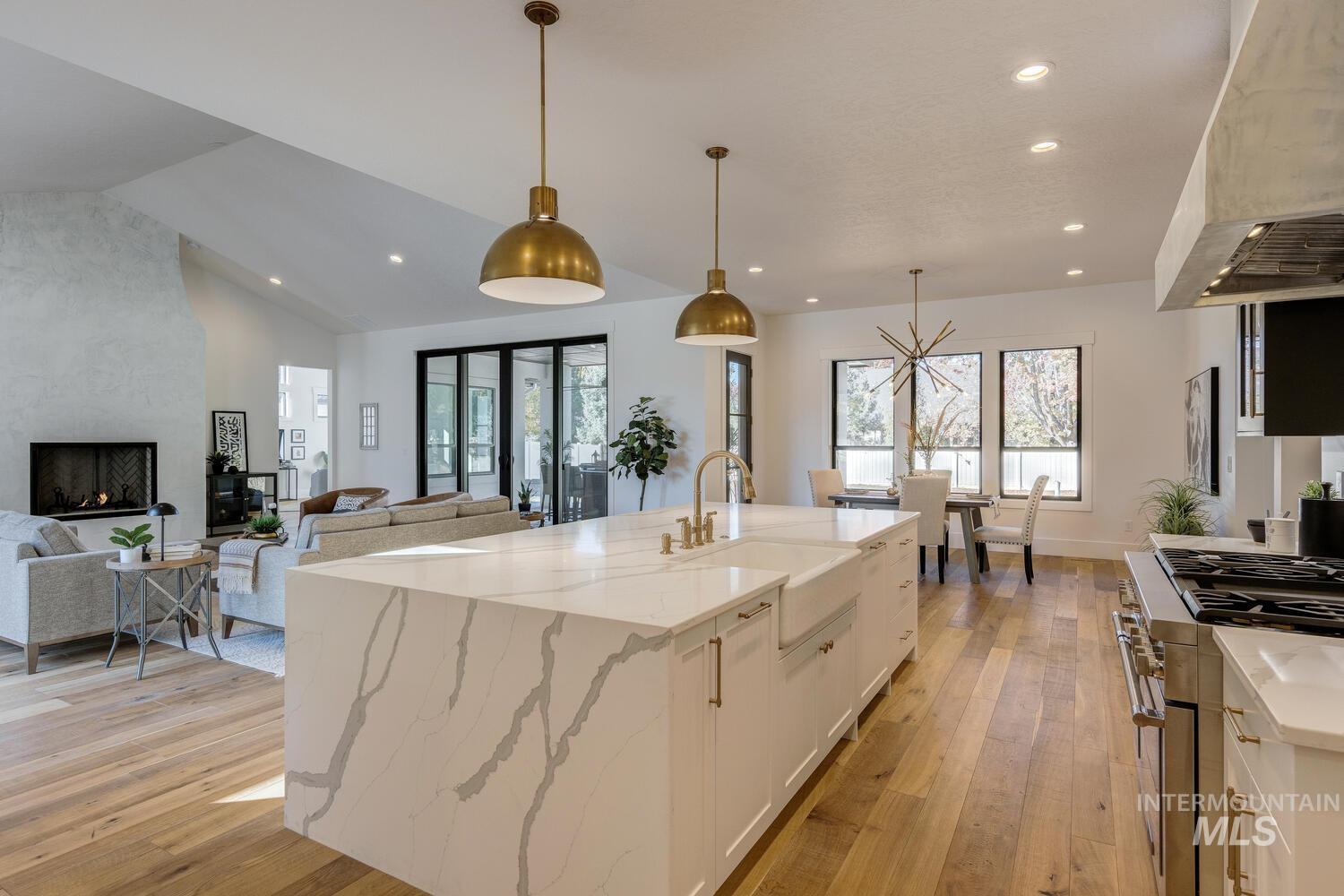 Kitchen featuring light stone countertops, range with two ovens, pendant lighting, white cabinets, and recessed lighting
