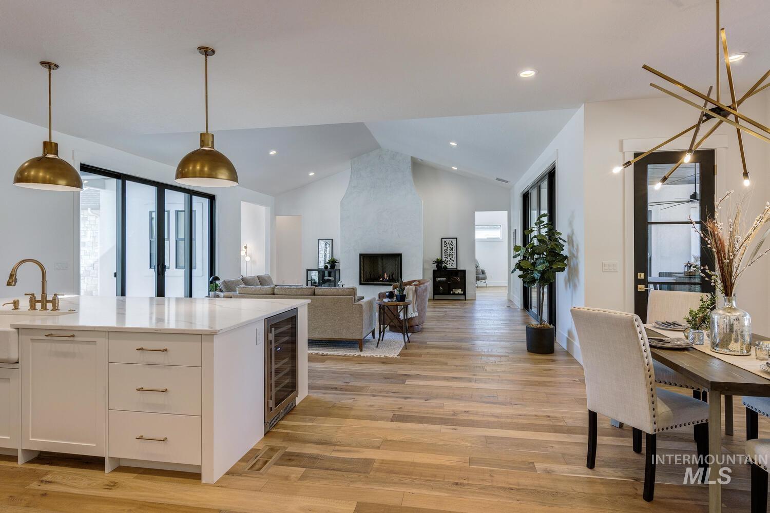Kitchen featuring pendant lighting, open floor plan, light wood-style flooring, light stone countertops, and recessed lighting