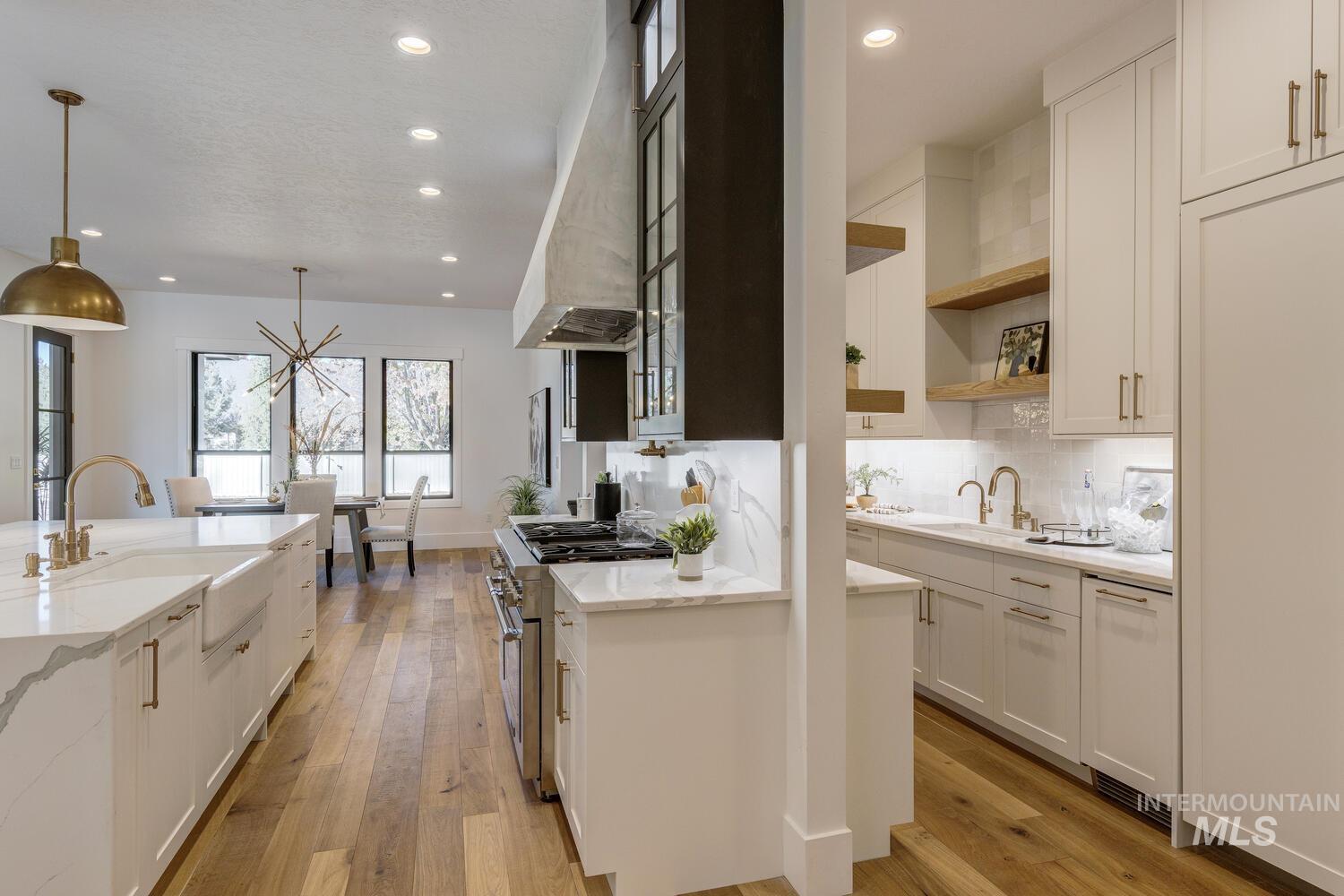 Kitchen featuring light stone counters, white cabinets, decorative backsplash, and recessed lighting