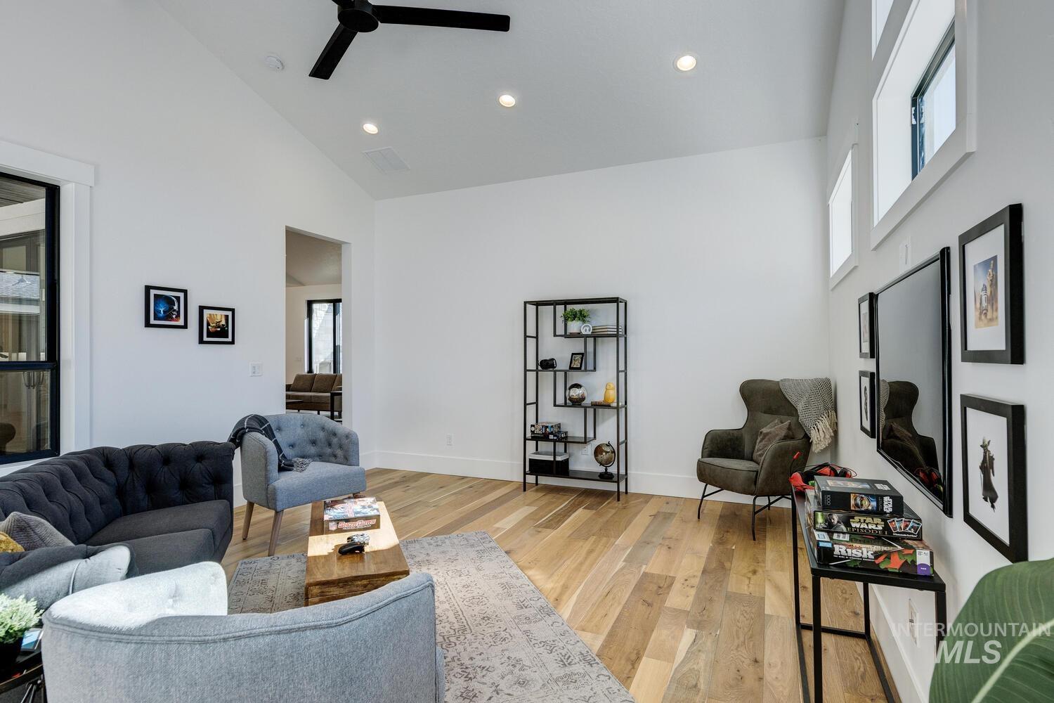 Living room featuring recessed lighting, plenty of natural light, high vaulted ceiling, light wood-type flooring, and a ceiling fan