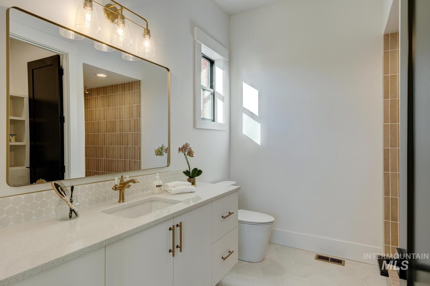 Full bathroom with light tile patterned floors and vanity