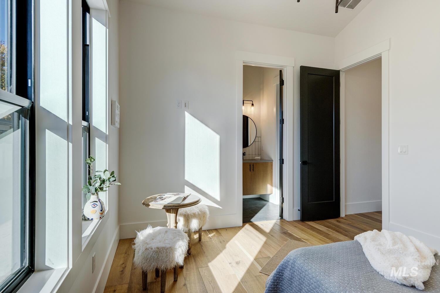 Bedroom with wood finished floors and connected bathroom