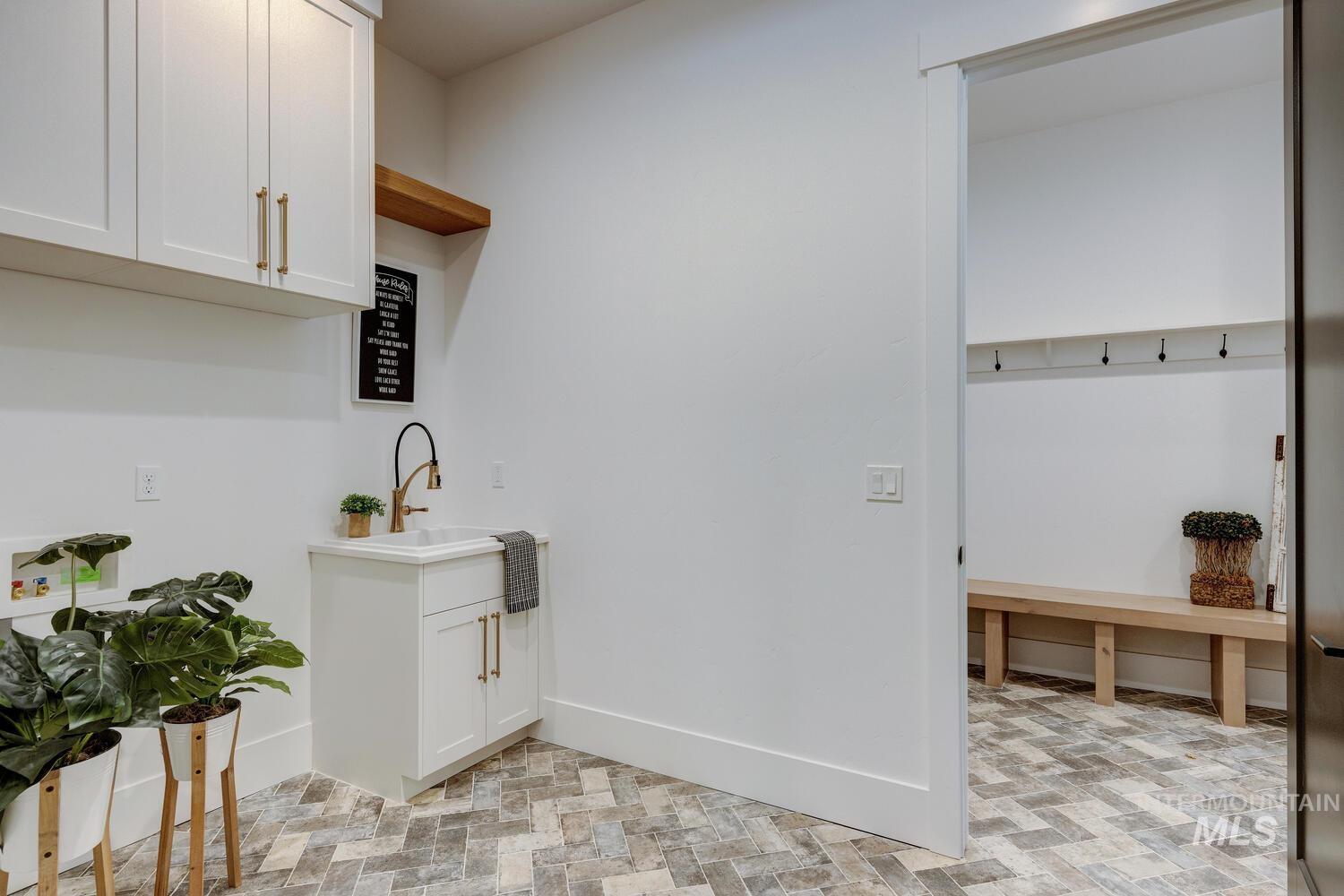 Laundry area featuring baseboards and a sink