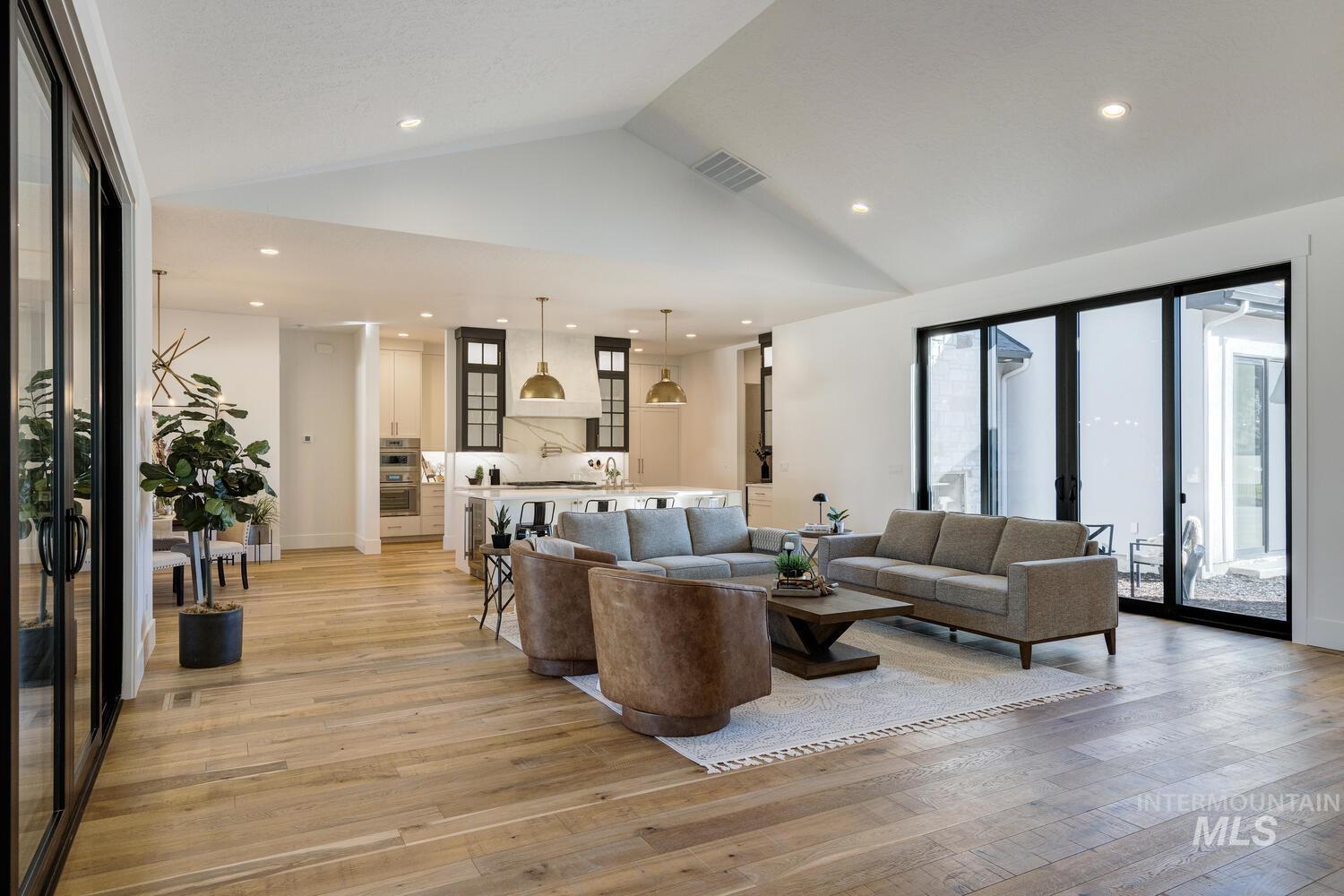 Living room featuring lofted ceiling, light wood-style floors, recessed lighting, and french doors