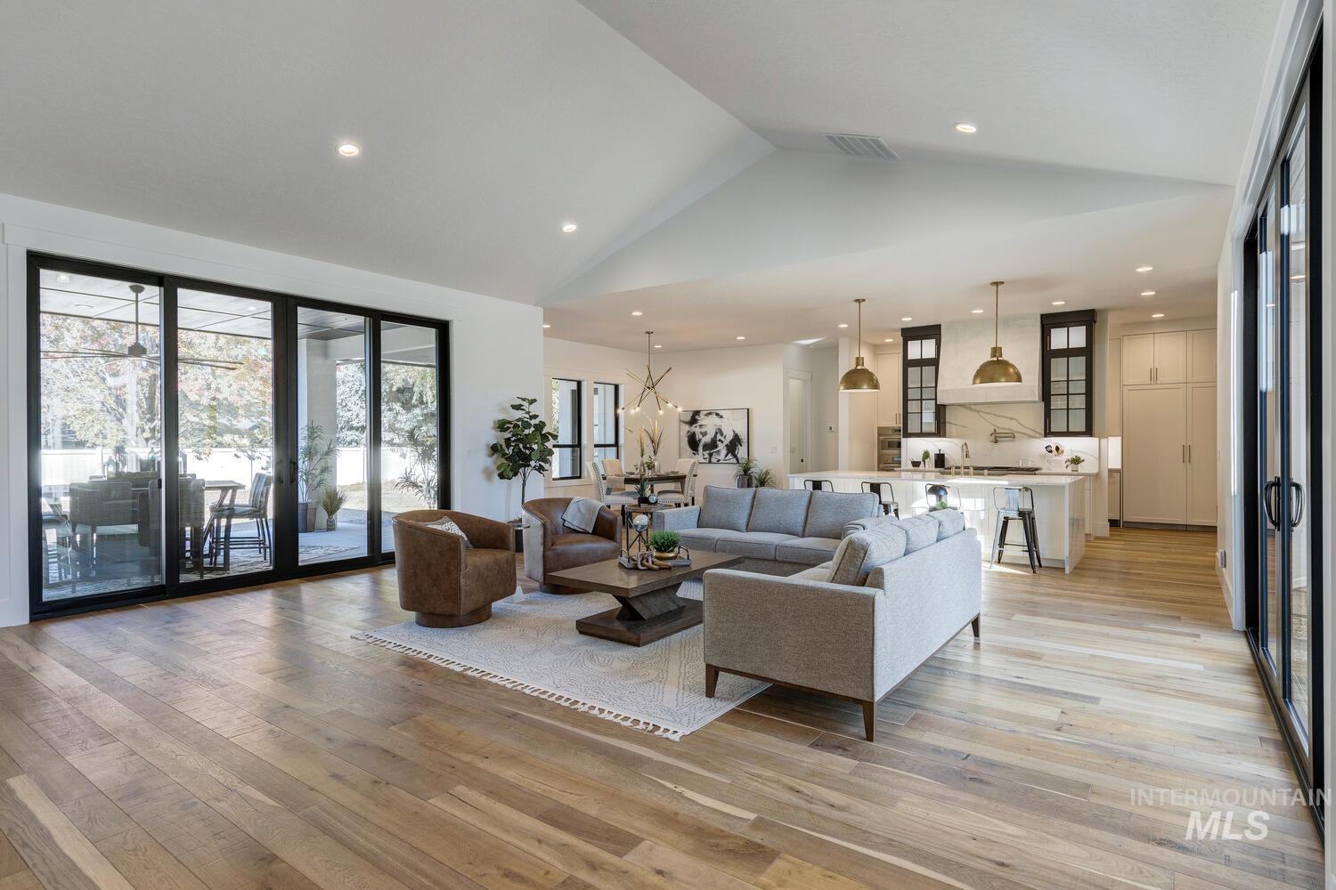 Living area featuring light wood-style floors, recessed lighting, and high vaulted ceiling