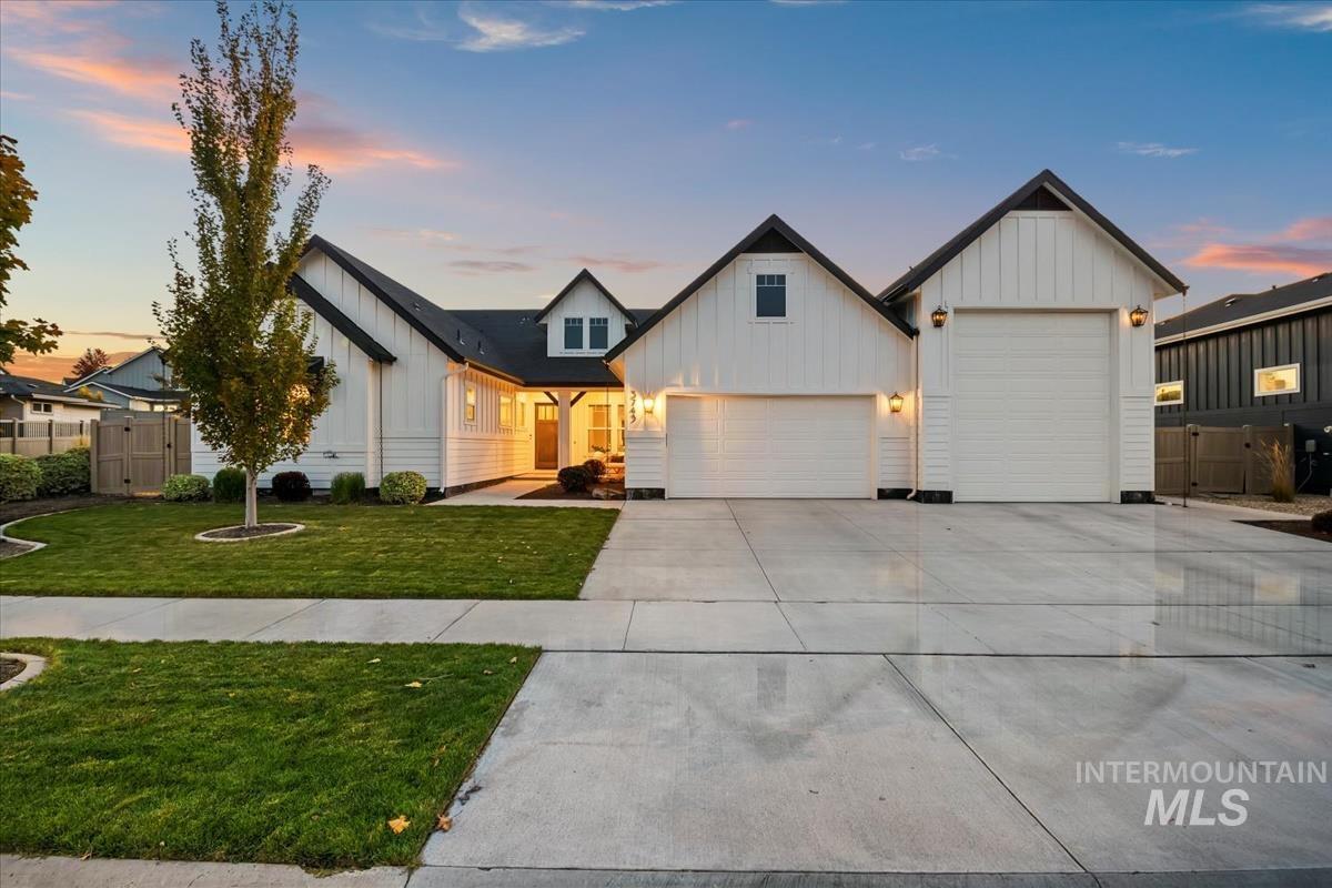 Modern inspired farmhouse with board and batten siding, driveway, a porch, and an attached garage