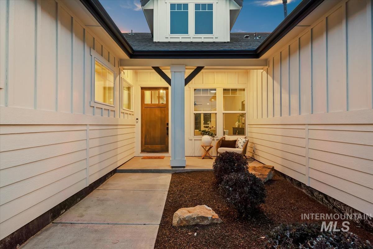 Entrance to property with board and batten siding and roof with shingles