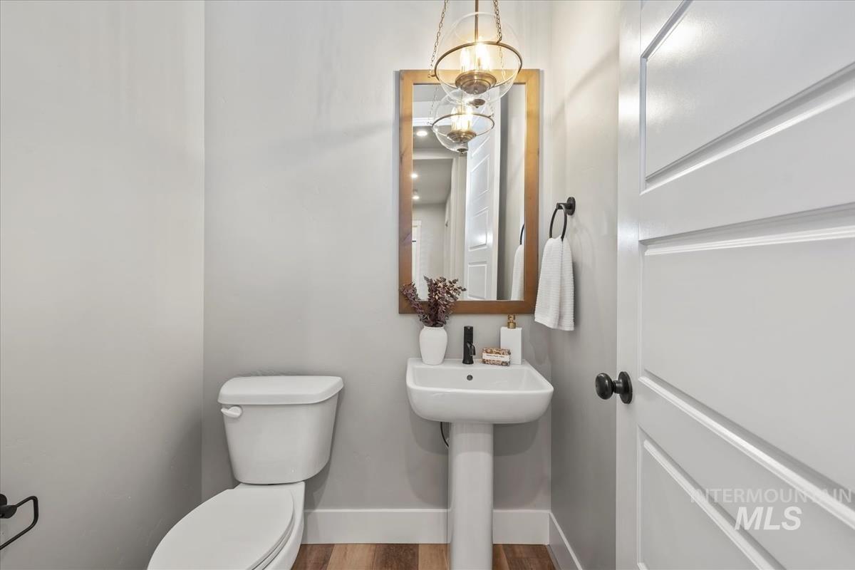 Bathroom featuring wood finished floors and a chandelier