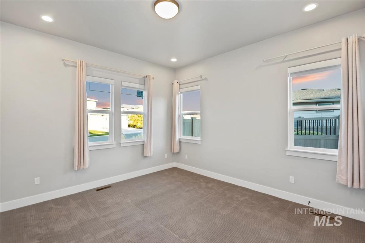 Carpeted empty room featuring recessed lighting
