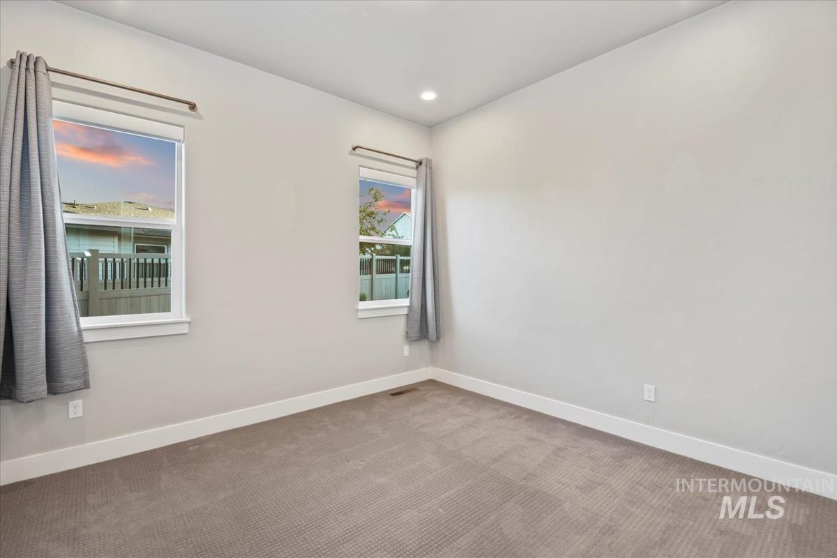 Carpeted spare room featuring baseboards and recessed lighting