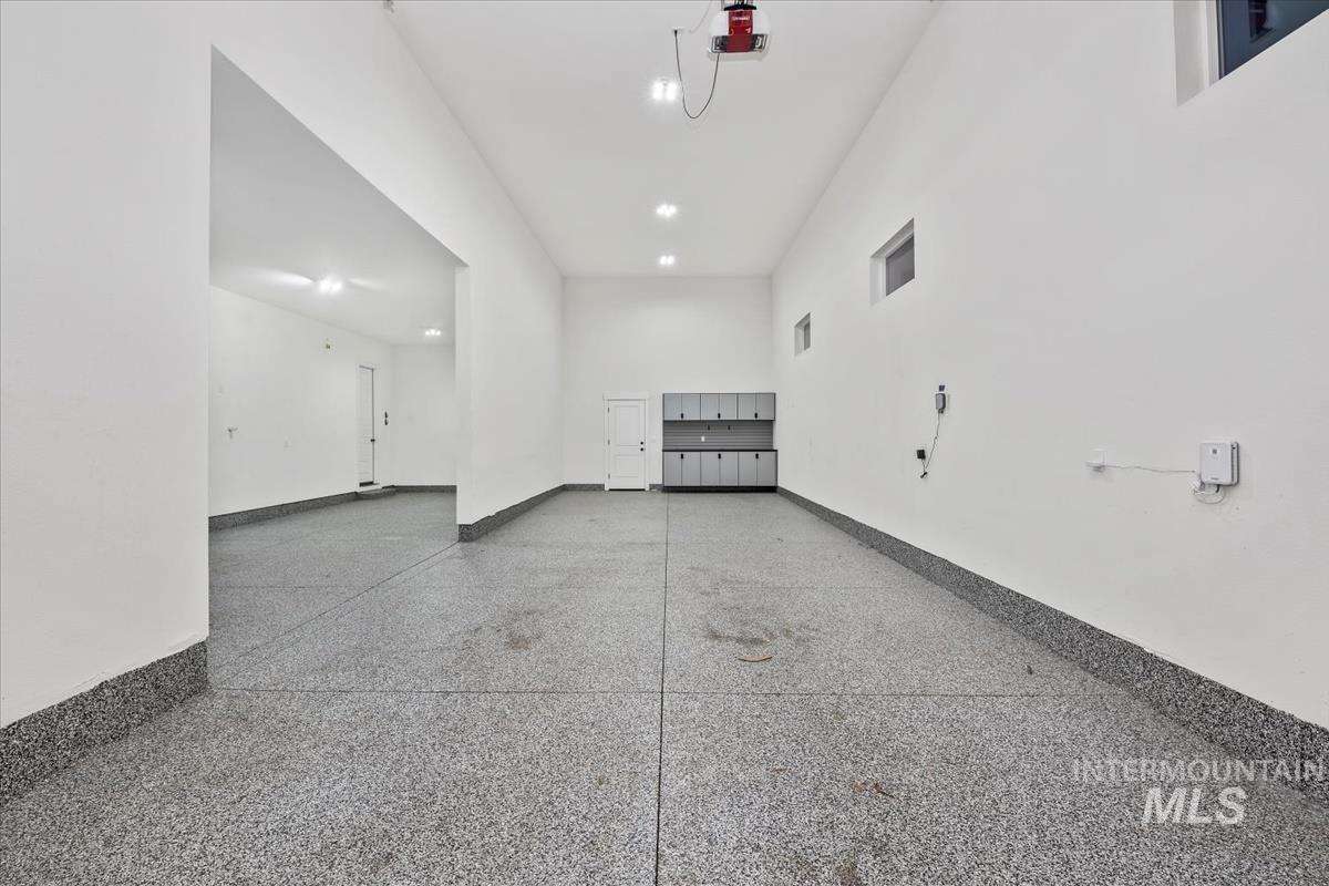 Garage featuring baseboards and a garage door opener