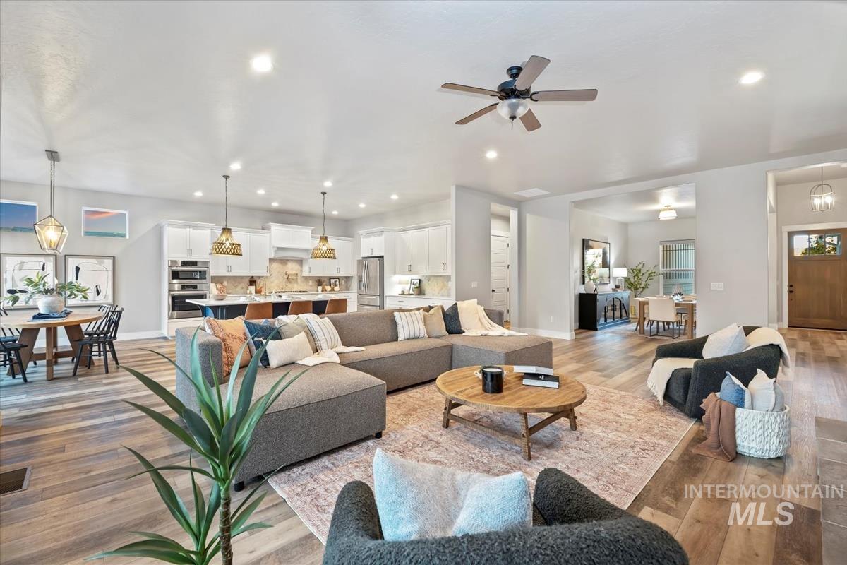 Living room featuring light wood-style floors, recessed lighting, and a ceiling fan