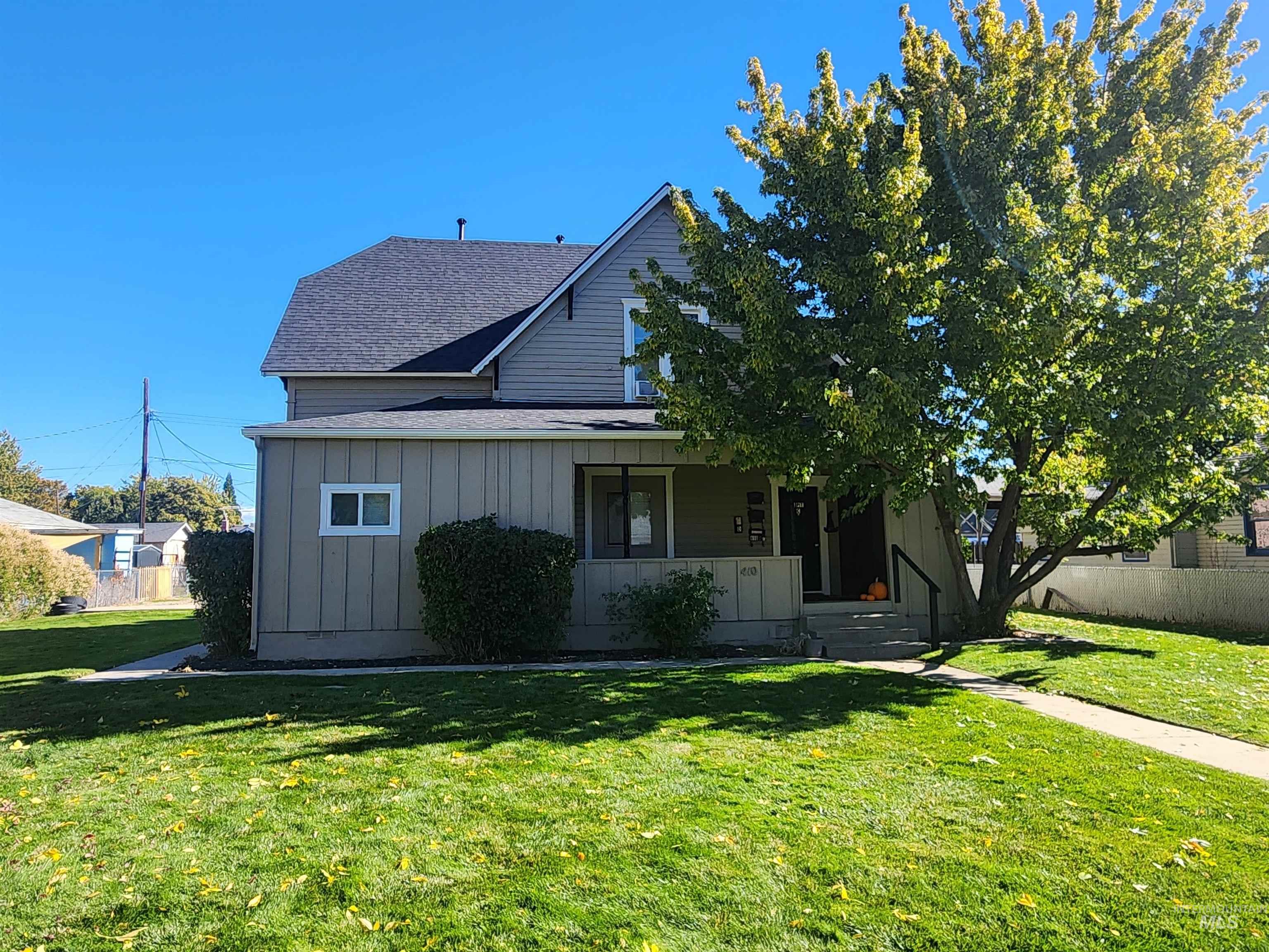 View of front of property with roof with shingles, board and batten siding, and covered porch