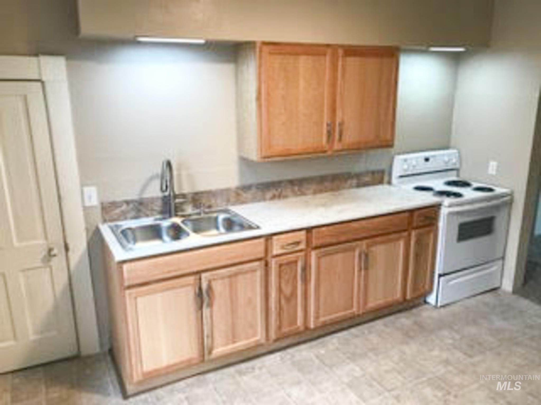 Kitchen featuring white range with electric stovetop and light countertops