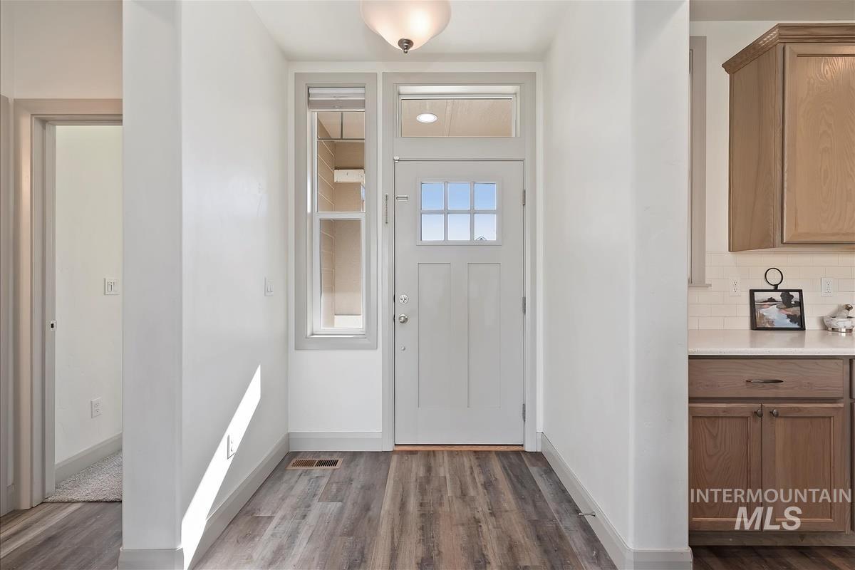Entryway with baseboards and dark wood-type flooring