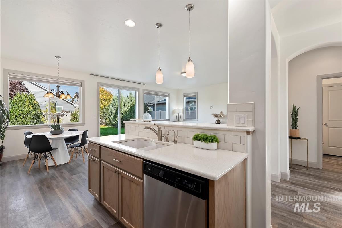 Kitchen with dishwasher, pendant lighting, a chandelier, backsplash, and recessed lighting