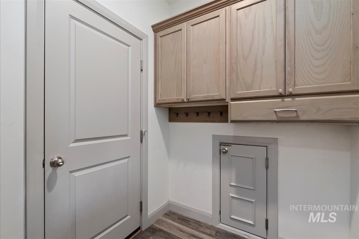 Laundry room featuring baseboards and wood finished floors