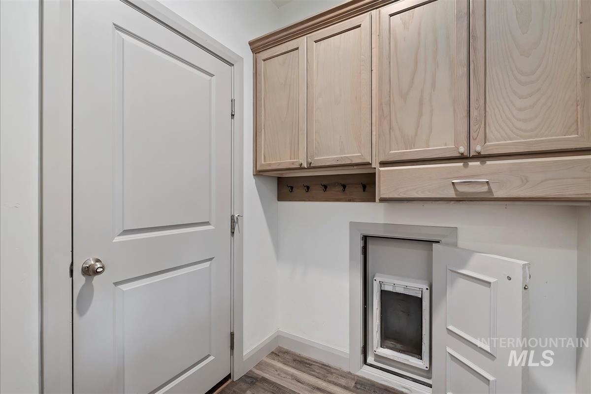 Laundry room with baseboards and light wood-type flooring