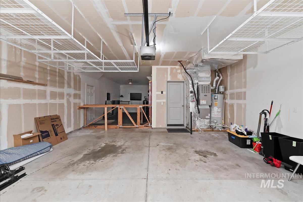 Garage featuring gas water heater, a garage door opener, and heating unit