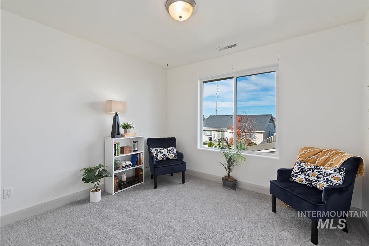 Sitting room featuring carpet and baseboards