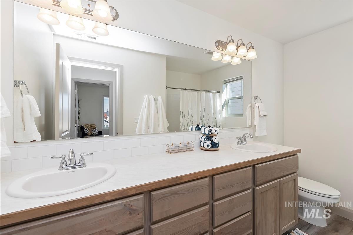 Full bath with double vanity and a shower with curtain