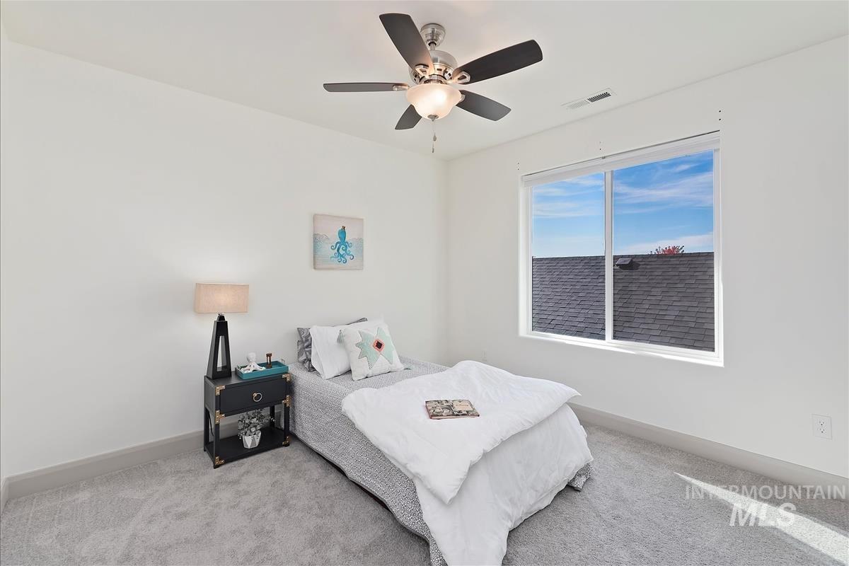 Carpeted bedroom featuring a ceiling fan and baseboards