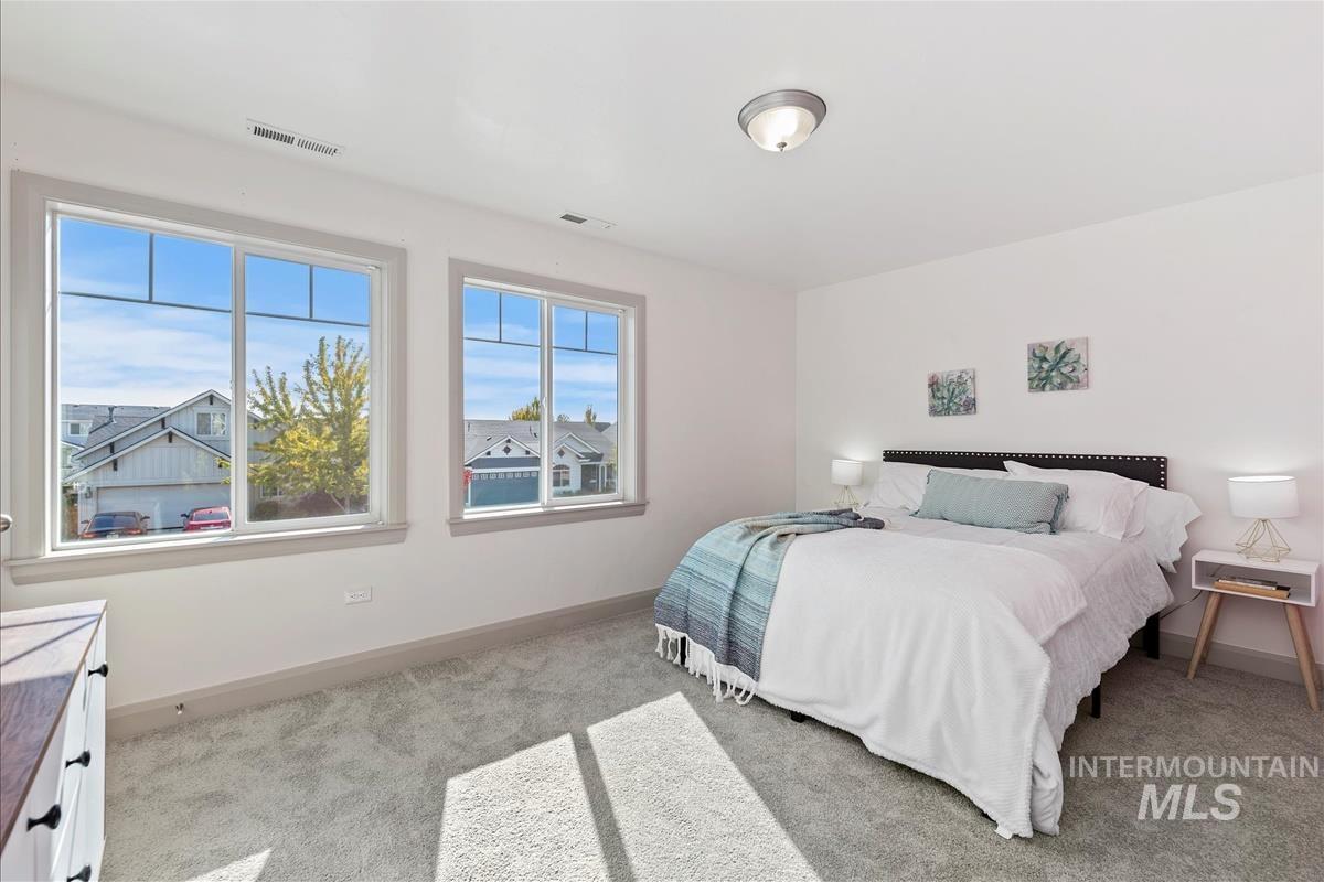Bedroom featuring light carpet and baseboards