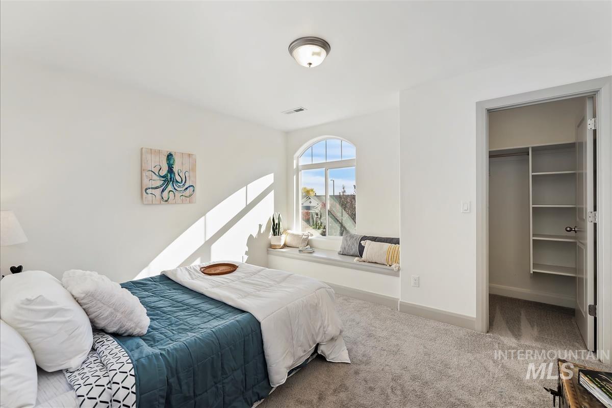 Bedroom with a walk in closet and carpet flooring