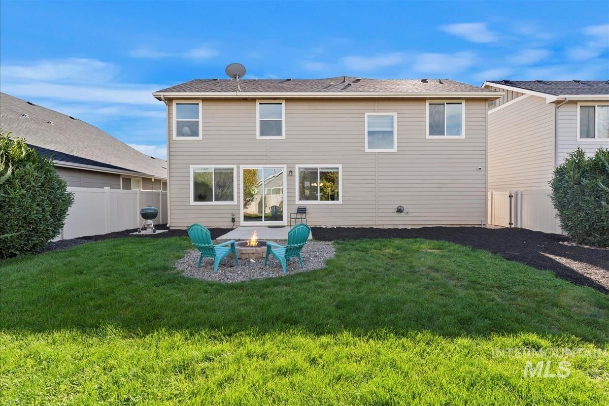 Back of property with a patio, an outdoor fire pit, and a fenced backyard
