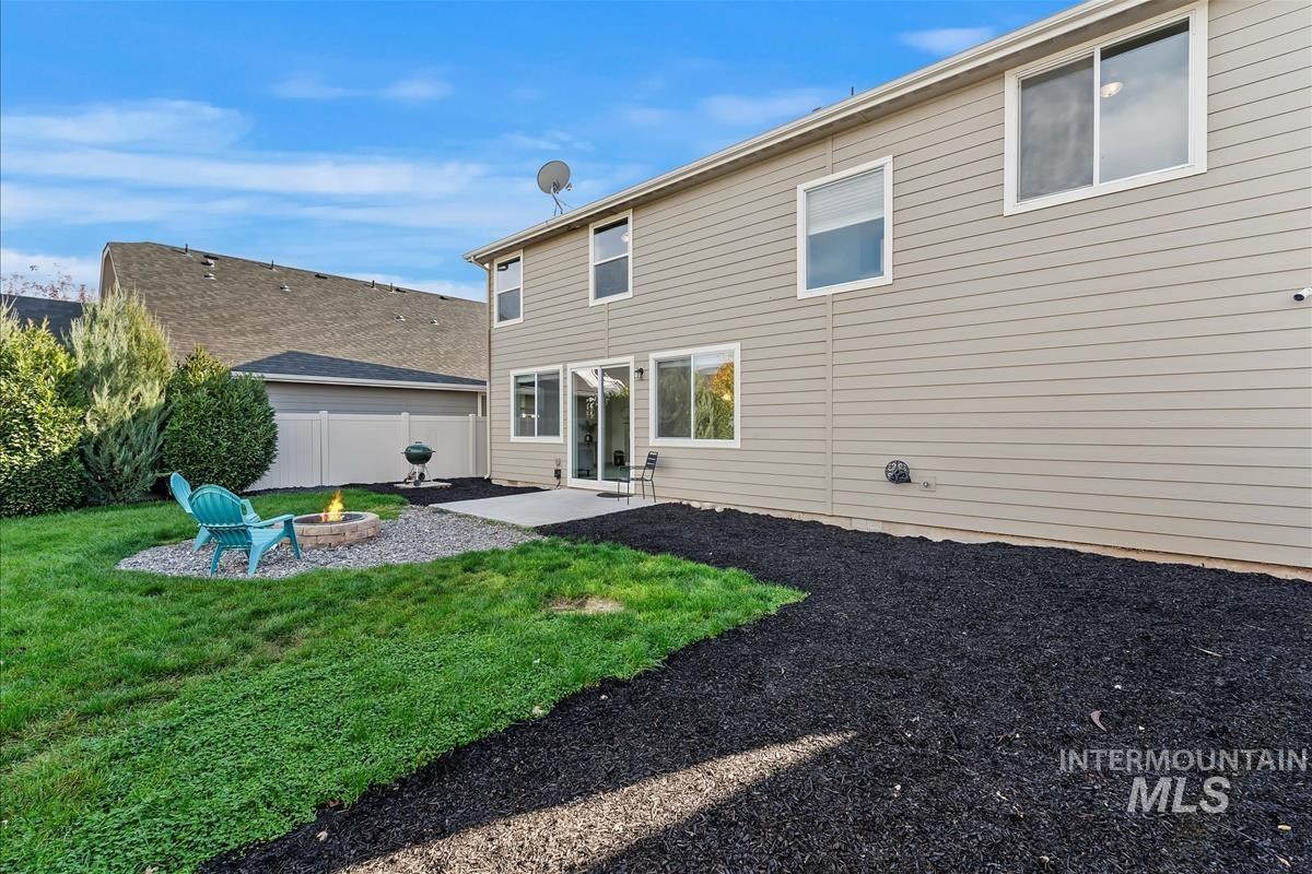 Rear view of house with a patio area and an outdoor fire pit