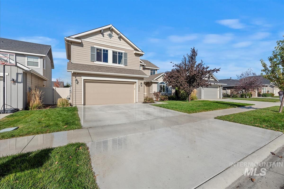 View of front of property with concrete driveway, a garage, and a shingled roof