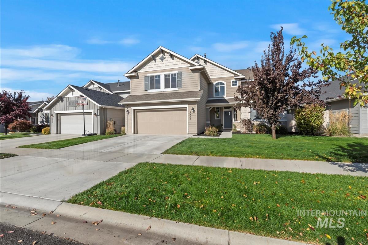 Craftsman inspired home featuring concrete driveway, a front yard, an attached garage, and a shingled roof