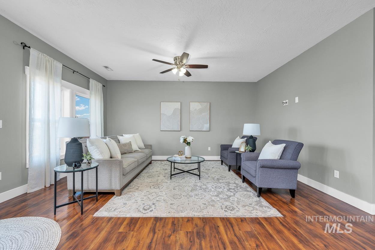 Living area with a ceiling fan and dark wood-style flooring