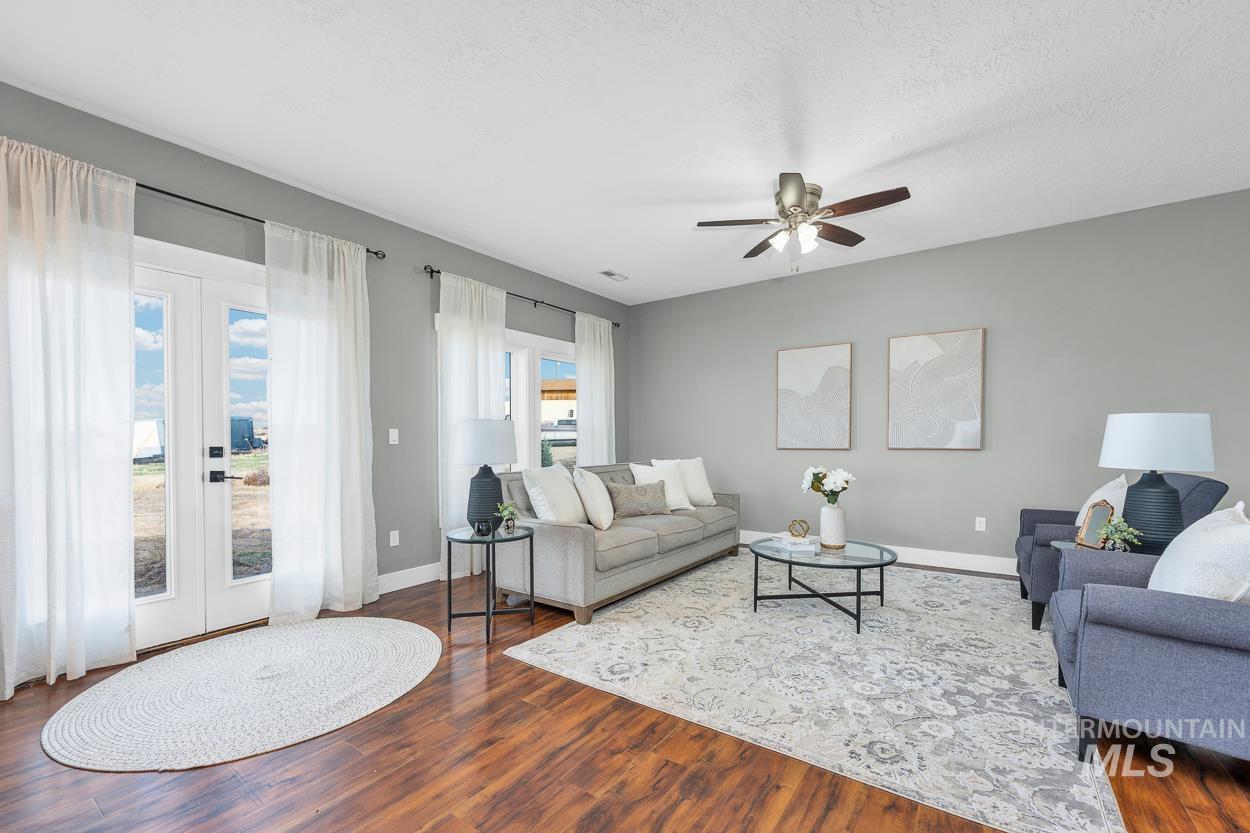 Living room featuring french doors, wood finished floors, ceiling fan, and a textured ceiling