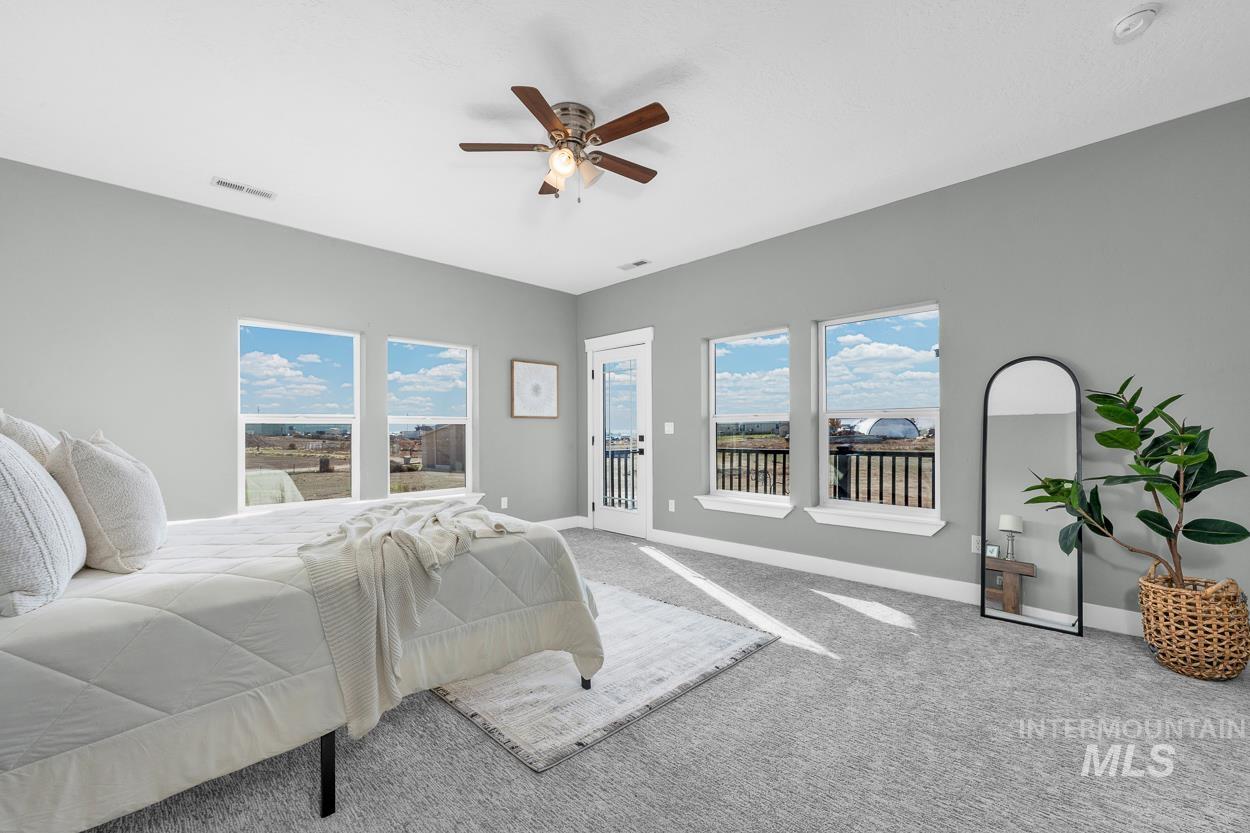 Bedroom with carpet floors, access to exterior, and a ceiling fan