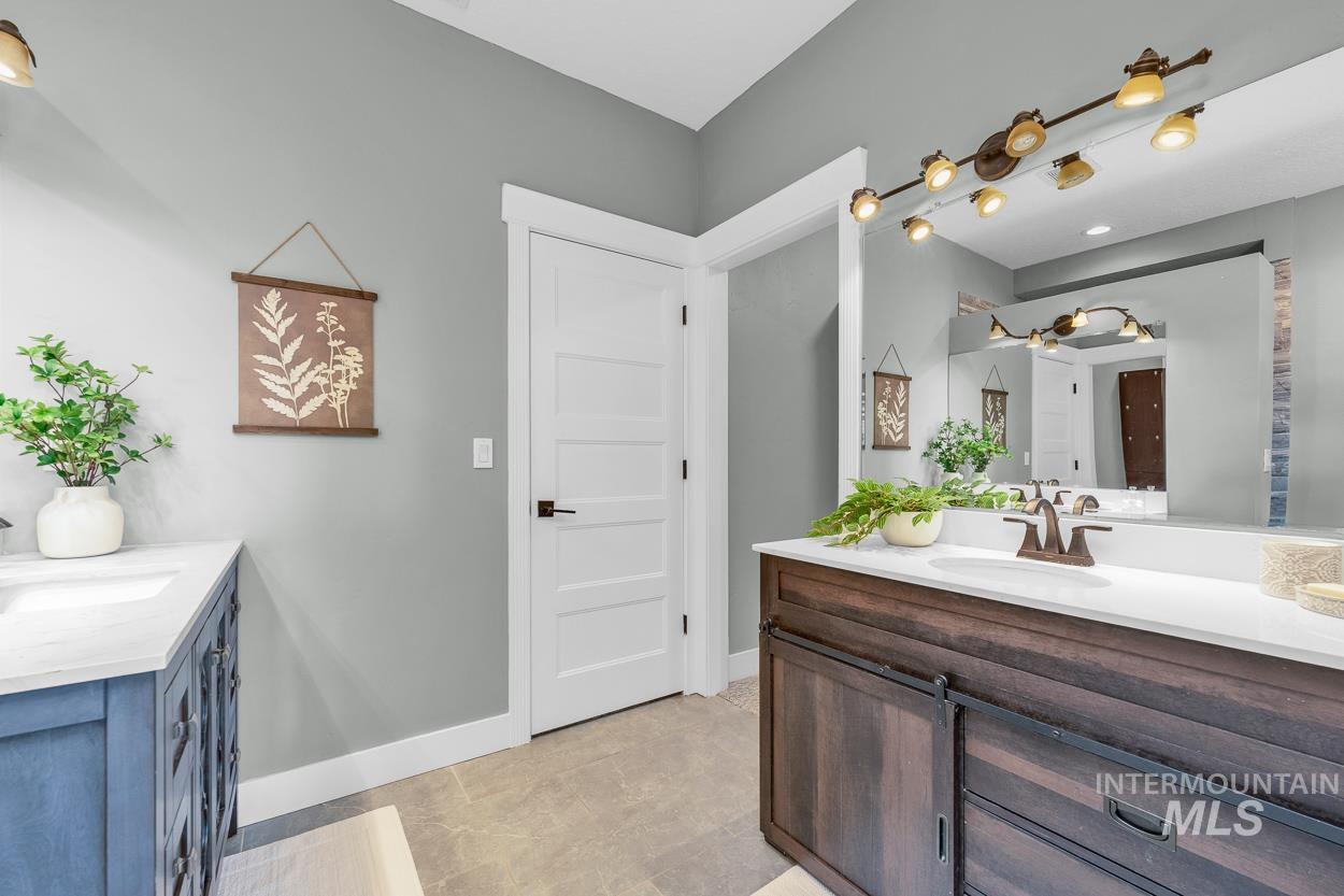 Full bathroom featuring two vanities and light tile patterned floors