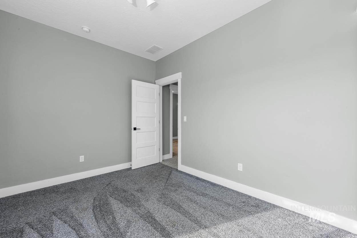Carpeted spare room with baseboards