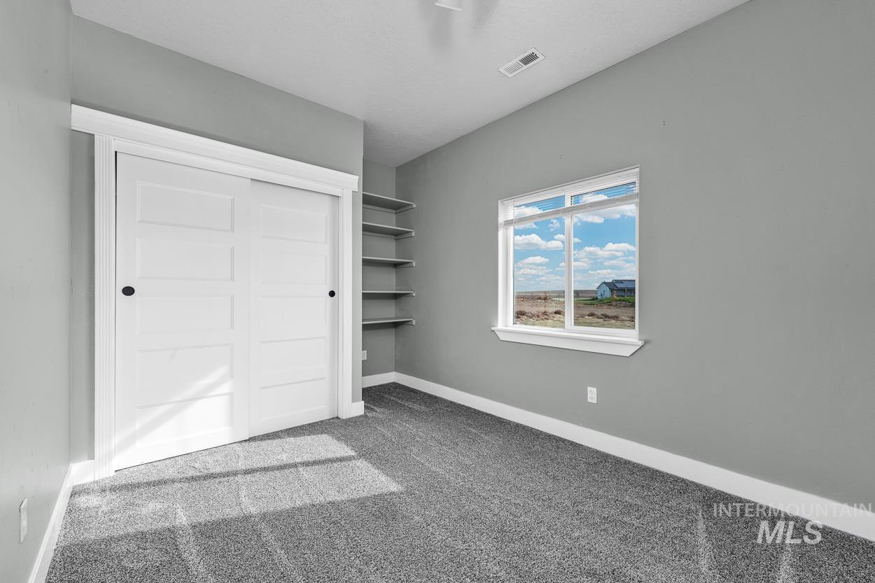 Unfurnished bedroom with light colored carpet and a closet